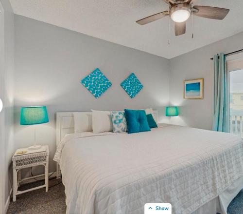 a bedroom with a large white bed with blue pillows at Fort Morgan Townhomes E7 in Fort Morgan