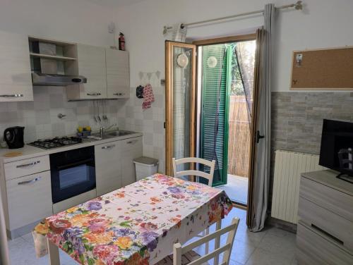 a kitchen with a table with a flowered table cloth at Casa del Coro in Perugia