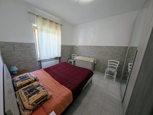 a bedroom with a bed and two chairs in it at Casa del Coro in Perugia