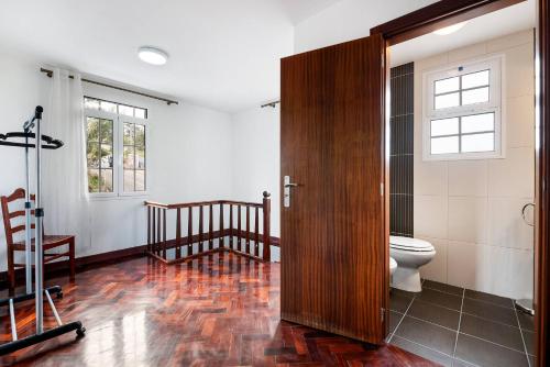 a bathroom with a toilet and a wooden door at Villa Santana by GALMI in Santana