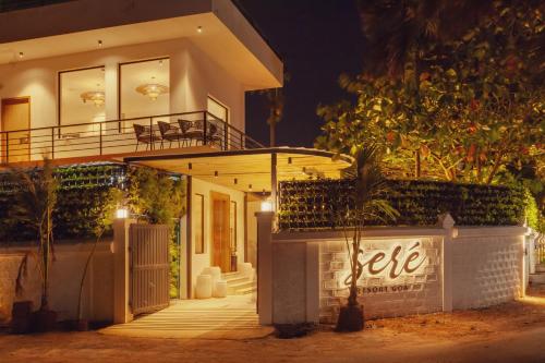a white house with a balcony at night at Sere Resort Goa in Goa