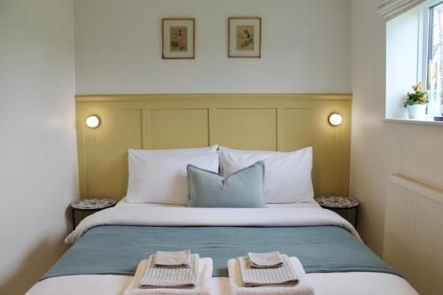 a bedroom with a bed with two towels on it at Modern Country Cottage Stay in Lympsham