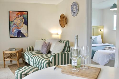 a living room with a couch and a bed at Modern Country Cottage Stay in Lympsham