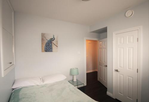1 dormitorio con 1 cama y una foto en la pared en Elegant Suite by Prowess en Saskatoon
