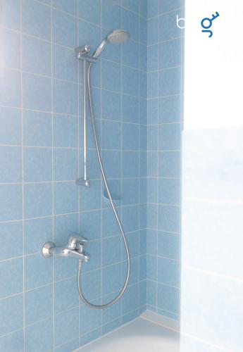 a shower in a bathroom with blue tiles at BEGE APARTMENTS ComfortLoft in Unna