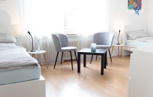 a bedroom with two chairs and a table and a bed at BEGE APARTMENTS ComfortLoft in Unna