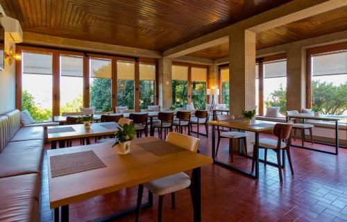 a restaurant with tables and chairs and windows at Villa Maria Caetana in Frazão
