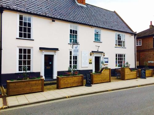 a white building with wooden planters on a sidewalk at Sutherland House in Southwold