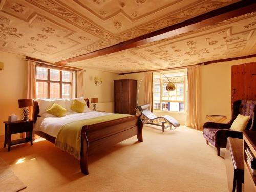 a bedroom with a large bed with a coffered ceiling at Sutherland House in Southwold