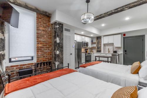 two beds in a room with a brick wall at Park Hotel Studio Suite 403 in Chattanooga