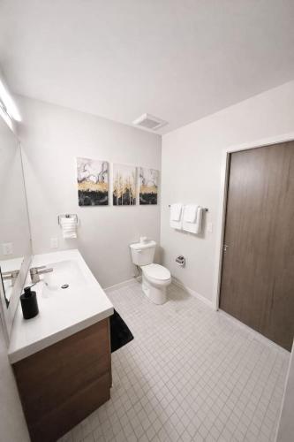 a white bathroom with a toilet and a sink at The Luxe Black Haven (340) in Des Moines