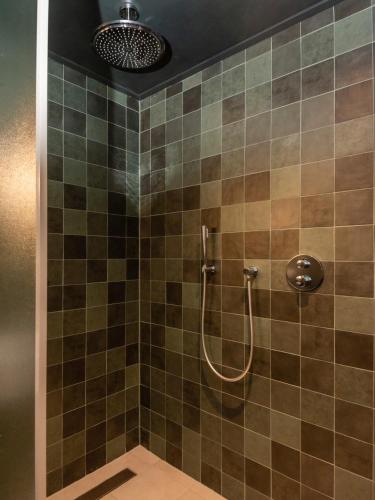 a bathroom with a shower with brown tiles at HARBOR HOUSE ZEELAND - nl in Goes
