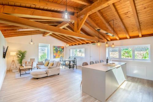 an open living room with wooden ceilings and a kitchen and living room at Espectacular apartamento a 10 minutos de Pamplona in Uterga
