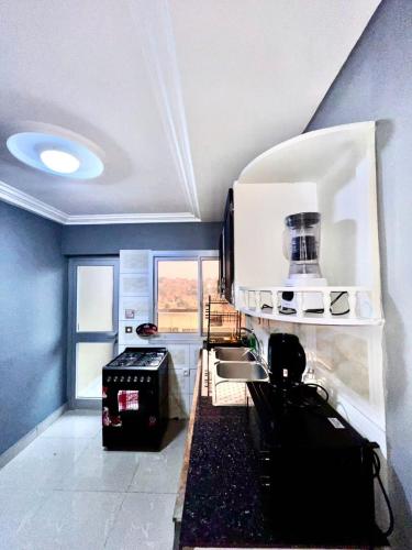 Cosy Appartment في ياوندي: مطبخ مع حوض وموقد الفرن العلوي
