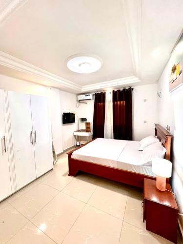 Cosy Appartment في ياوندي: غرفة نوم بها سرير كبير وتلفزيون
