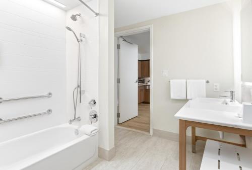 a white bathroom with a tub and a sink at Element by Marriott Houston Katy in Katy