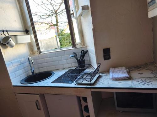 a kitchen counter with a sink and a window at Studio 4 places - Centre-ville in Ax-les-Thermes