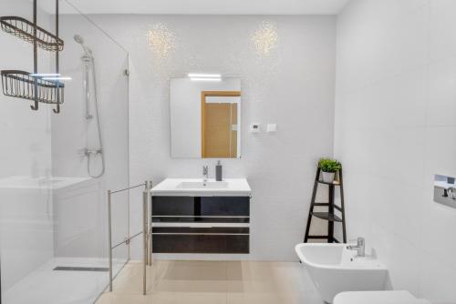 a white bathroom with a sink and a mirror at Penthouse by the Marina in Lagos