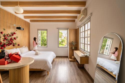 a room with two beds and a mirror at Chạm's Hotel & Homestay in Ho Chi Minh City
