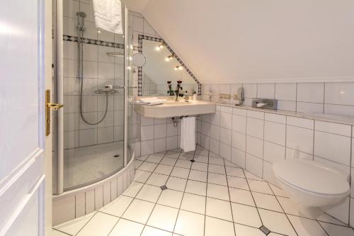 a bathroom with a shower and a sink and a toilet at Hotel Altes Gymnasium in Husum