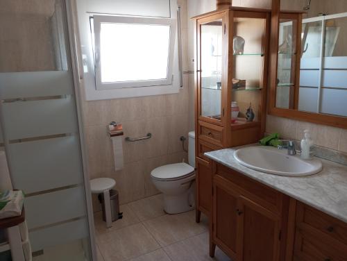 a bathroom with a toilet and a sink and a window at Un lugar tranquilo y relajado en Pedrasanta in La Salud