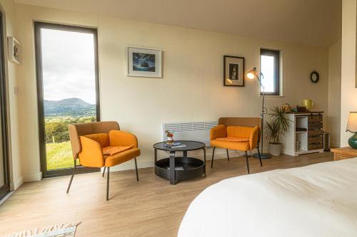 a hotel room with a bed and two chairs and a table at Oaklane Glamping Cabins in Kenmare