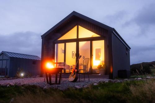 a small house with a guitar in front of it at Oaklane Glamping Cabins in Kenmare
