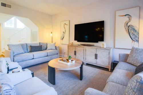 a living room with a couch and a tv at Harbour Town Haven in Hilton Head Island