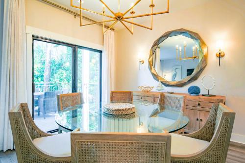 a dining room with a glass table and a mirror at Harbour Town Haven in Hilton Head Island