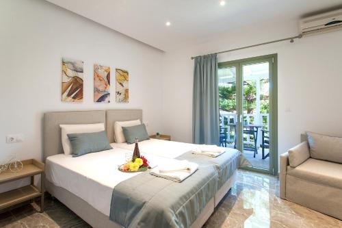 a bedroom with a bed and a couch and a chair at 3 Goddesses' studios in Koukounaries