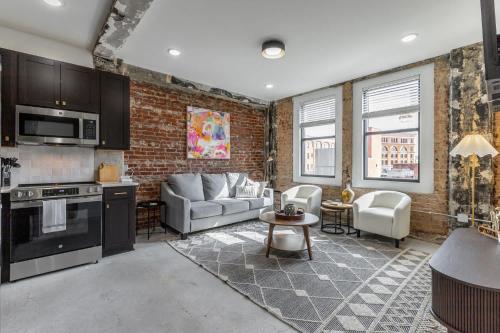 a kitchen and living room with a brick wall at Park Hotel 2BR Suite 406 in Chattanooga