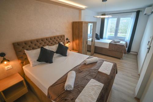a bedroom with a large bed and a mirror at Five stars in Dubrava