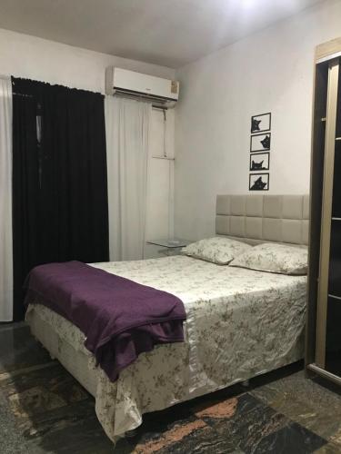 a bedroom with a bed with a purple blanket at casa boa vista in Recife