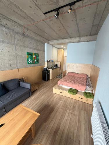 a bedroom with a bed and a couch in a room at Art house in Kʼumlistsʼikhe