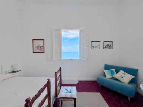 a bedroom with a bed and a chair and a window at La Torre in San Vincenzo