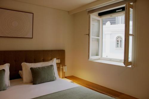 a bedroom with a bed and a window at Rossio Garden Suites in Lisbon
