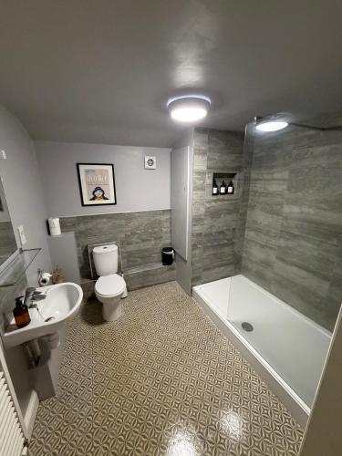 a bathroom with a toilet and a tub and a sink at The Cherry Tree in Woodbridge