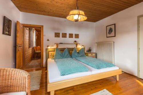 a bedroom with a large bed with blue pillows at Bauernhof im Wiesengrund in Maria Luggau
