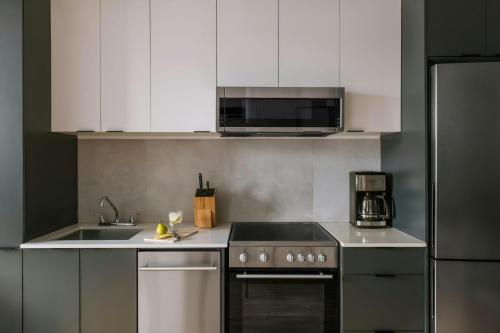 a kitchen with a stove and a sink and a microwave at The Alexander Hotel - Old Montreal in Montréal