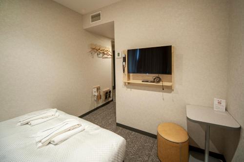 a hotel room with a bed and a flat screen tv at Hotel Il Fiore Kasai Annex in Tokyo
