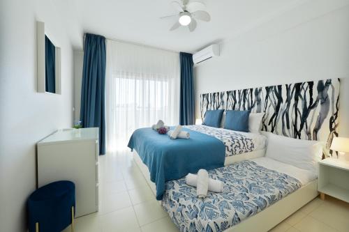 a bedroom with a blue and white bed and a window at Casa Azul 3 - Senhora da Rocha, Algarve in Porches