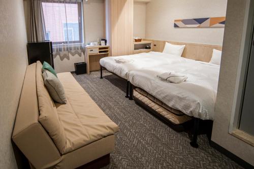 a hotel room with a bed and a couch at Hotel Il Fiore Kasai Annex in Tokyo
