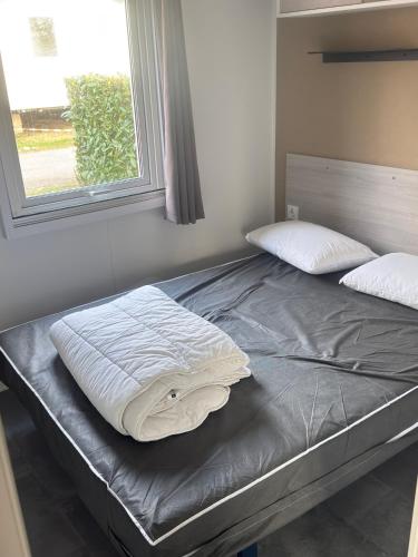 a bed sitting in a room with a window at Lambé in Pont-Aven