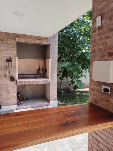 a fireplace in a brick wall with a wooden floor at Terroir Village - Complejo en Mendoza in Guaymallen