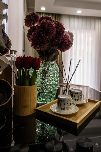 a table with two vases with flowers on it at Smartly Designed Cozy 1BR Apartment in Antalya