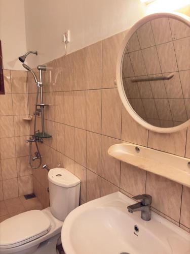 a bathroom with a toilet and a sink and a mirror at Fairview Villa in Hikkaduwa