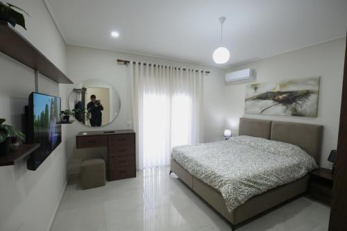 a bedroom with a bed and a tv and a mirror at The Swan Nest 1 in Pogradec