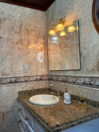 a bathroom with a sink and a mirror at Hospedagem Flor de Alissah in Arraial do Cabo