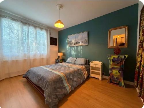 una camera da letto con un letto e una parete verde di Cosy Coty a Tours