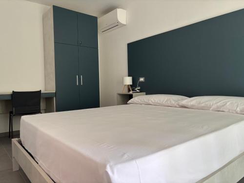 a large white bed in a bedroom with a blue wall at Giorgia's House in Silvi Marina